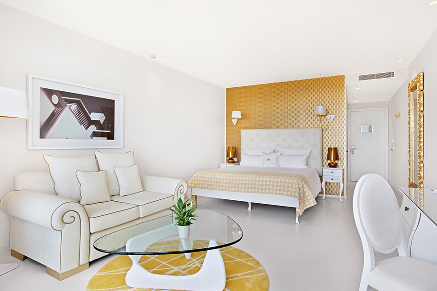 The golden deluxe suite with chic sofa and freshly made bed