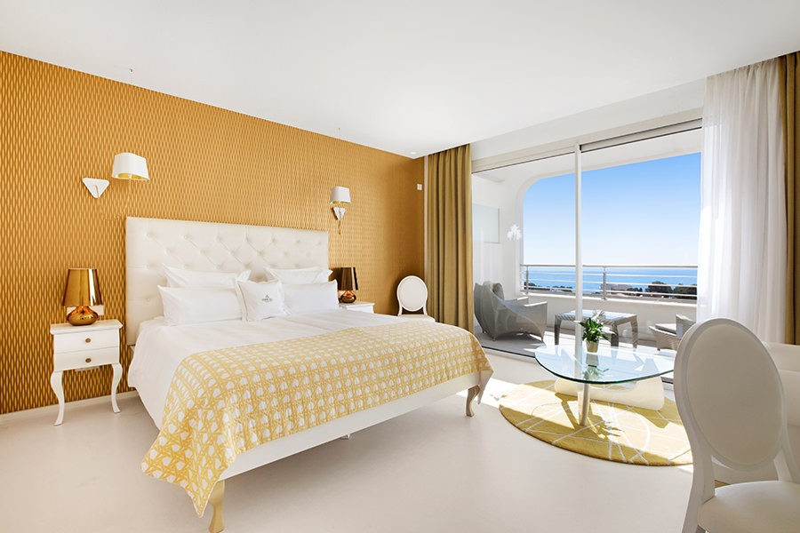 The golden bed of the penthouse suite overlooking the balcony and the sea