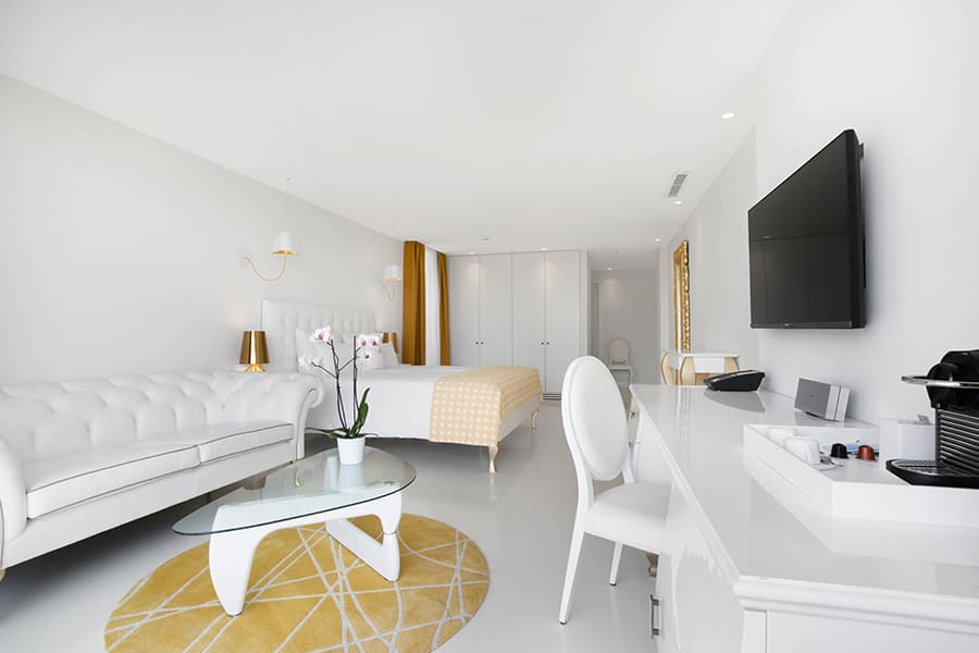 Eine weitläufige, helle Hotelsuite gestaltet mit goldenen Akzenten