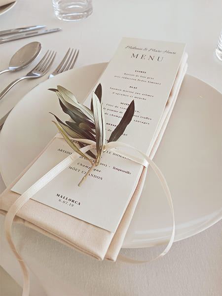 Mesa decorada con un menú y plantas en el plato