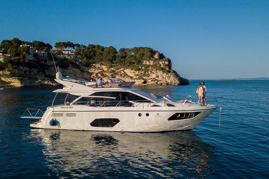 Un yate está pasando por la costa de Mallorca sobre el mar azul