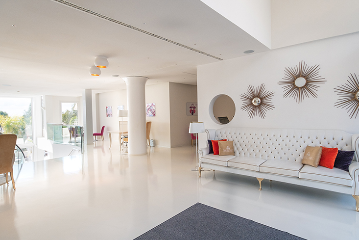 The cream colored entrance hall of Portals Hills Hotel with an elegant sofa and breathtaking views
